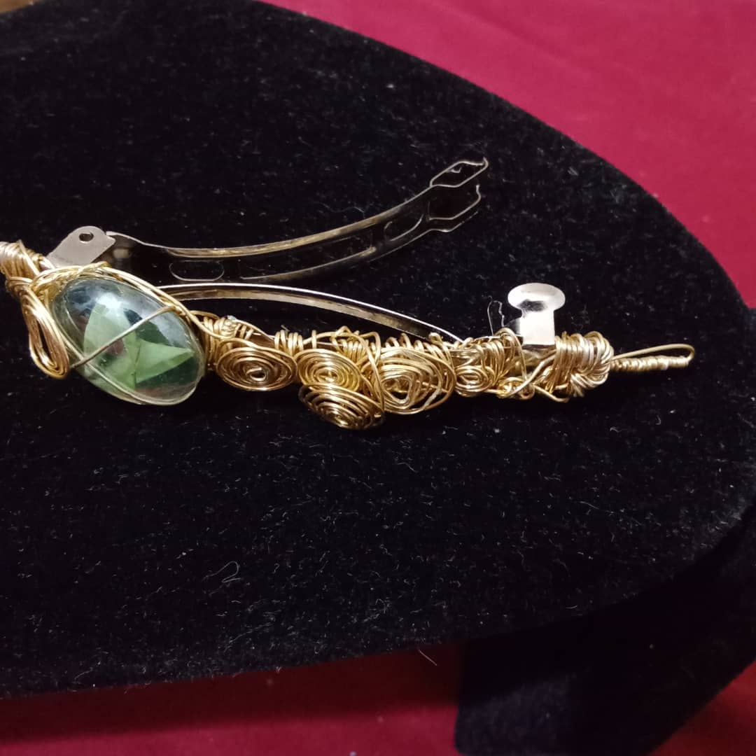 Wire wrapped hair clip with green cat's eye like jewel.