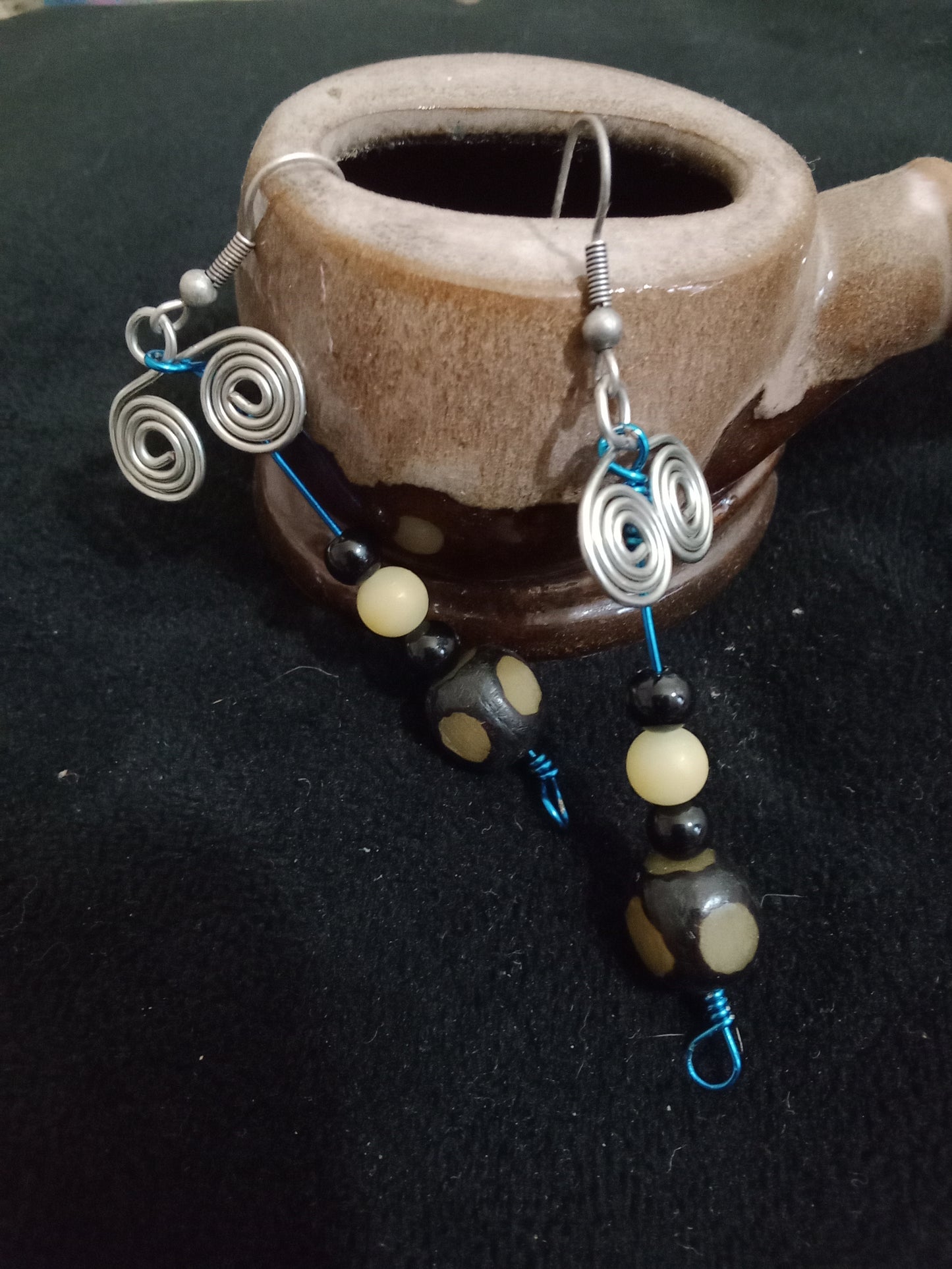 Beaded blue wire with silver wire double spiral earrings. Cloudy off white round beads, small black round beads, and black cubed beads