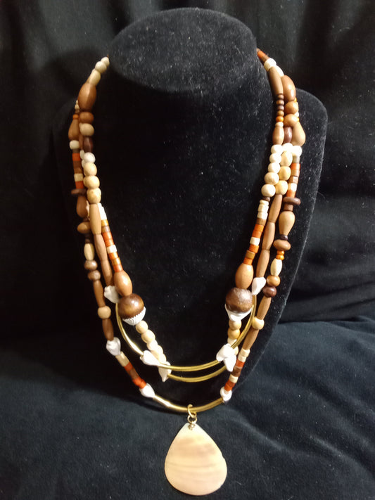 Three corded necklace with brown wooden beads of various shades and sizes accented with shells and golden tube beads.