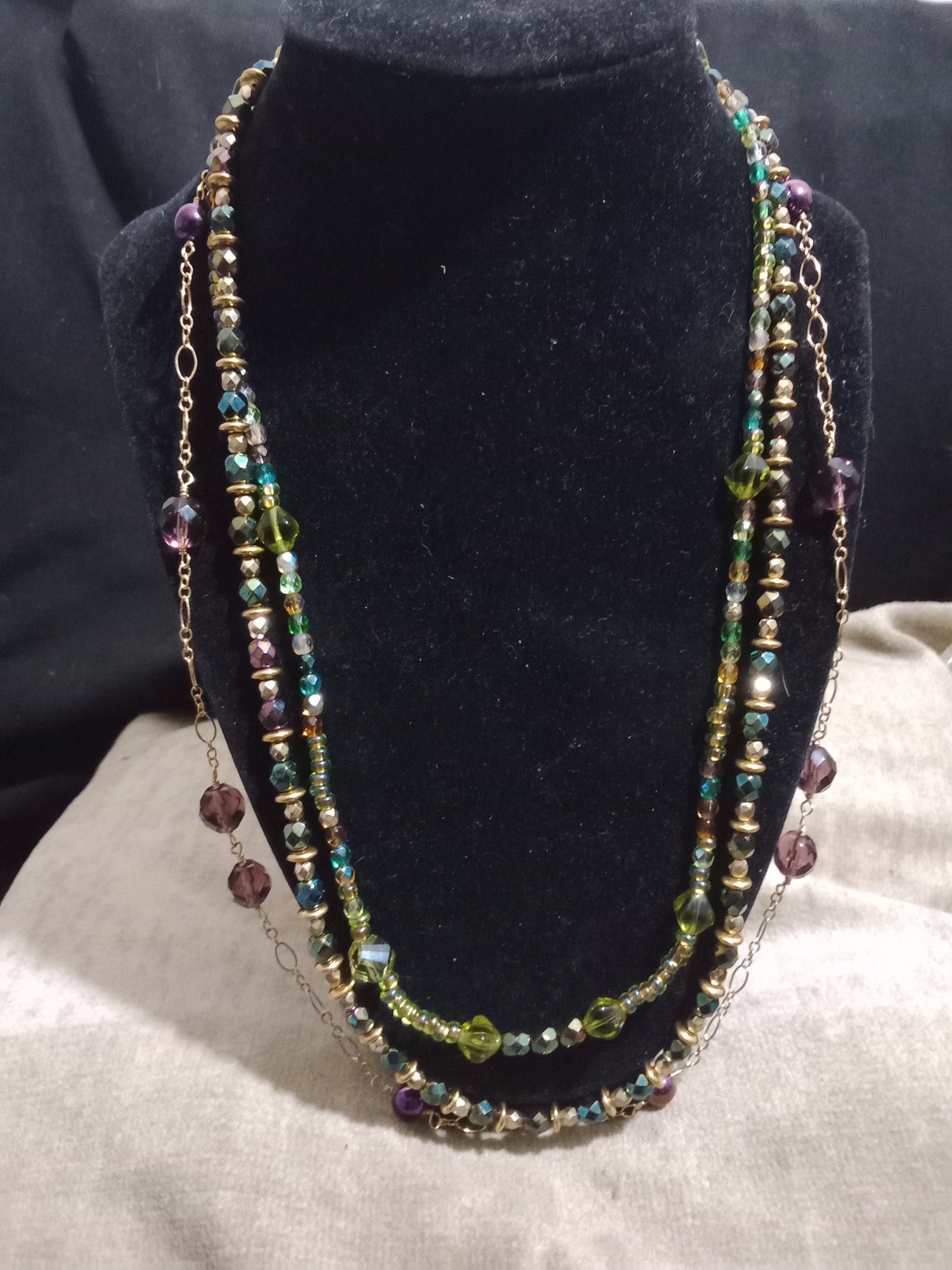 Two cord beaded necklace with gold chain. Various beads of blue, green, and purple