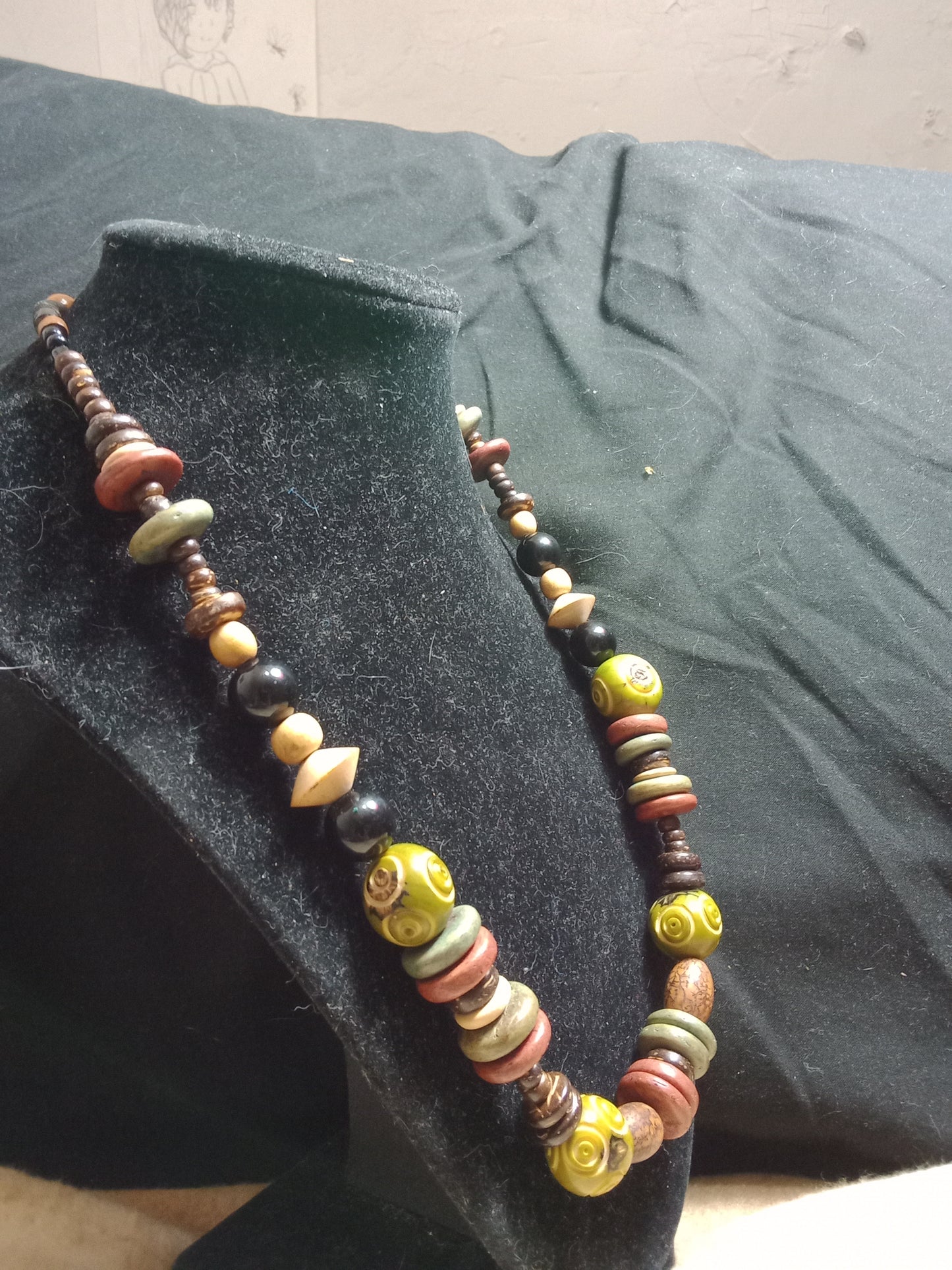 Multi-colored beaded cord necklace. Beads vary from round to flat, large to small. 21.5 inches