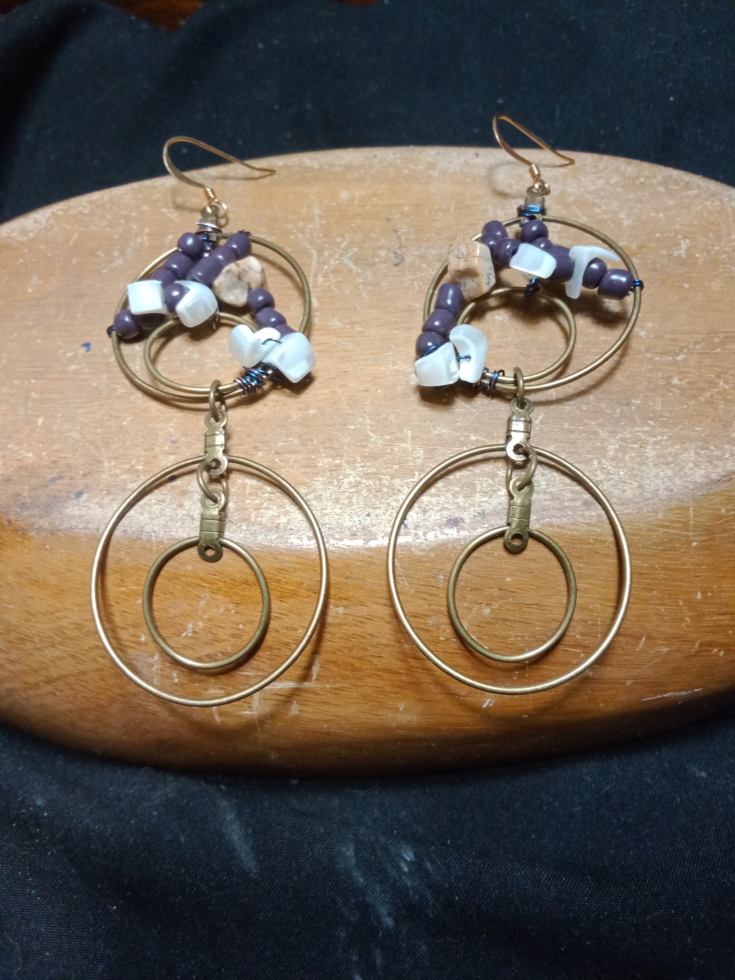 Two tier double hooped earrings with weave pattern in the top tier. Purple acrylic beads, brown acrylic stone beads, with white acrylic dove beads. Dangles to 3.5 inches